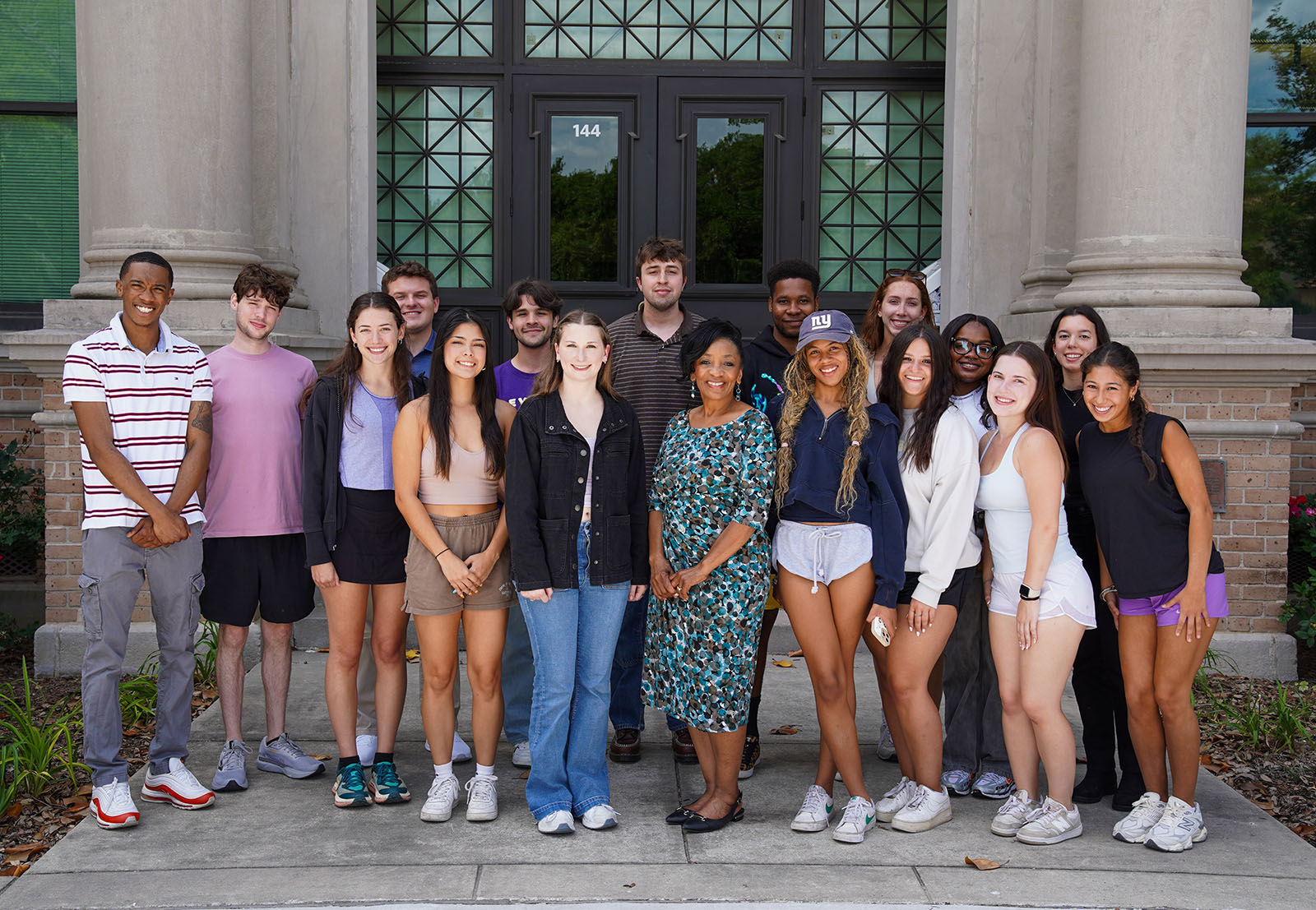 Group photo of team members in front of the Manship School building