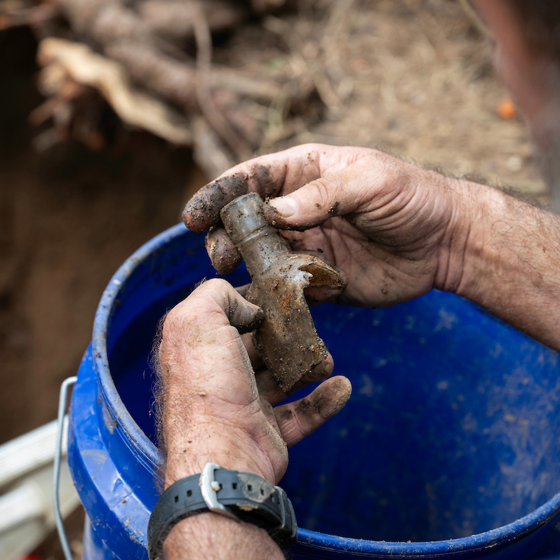 Gloved hand holding an excavated artifact