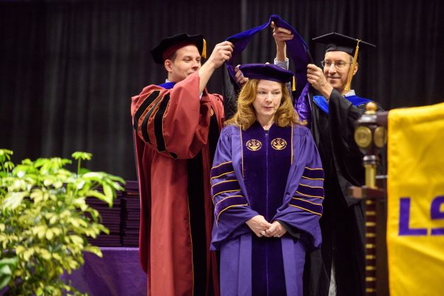 PhD student is hooded at graduation ceremony.