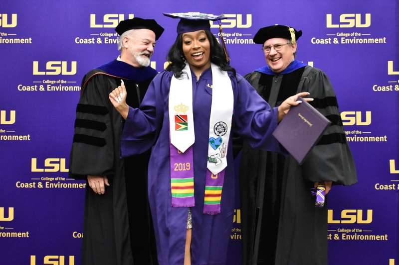 a graduate dances as she receives her diploma